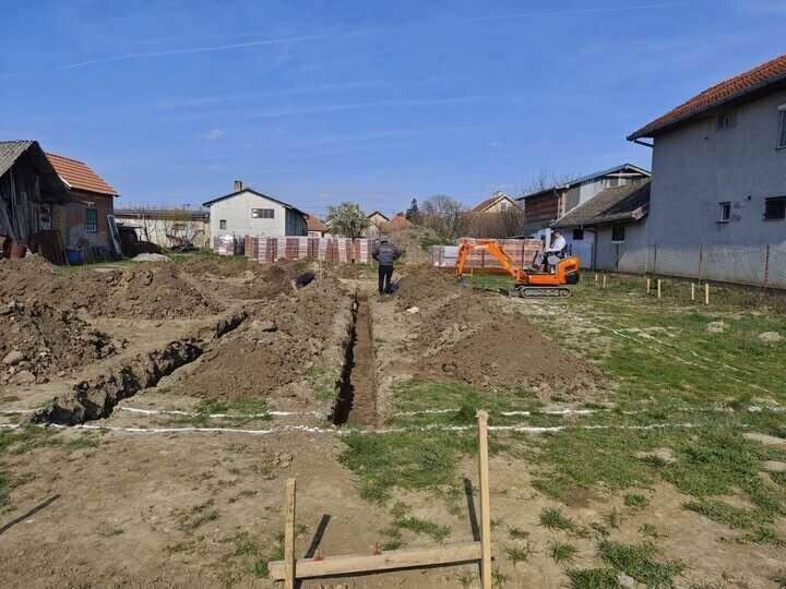 Mini bager na placu kopa kanale za grejne instalacije